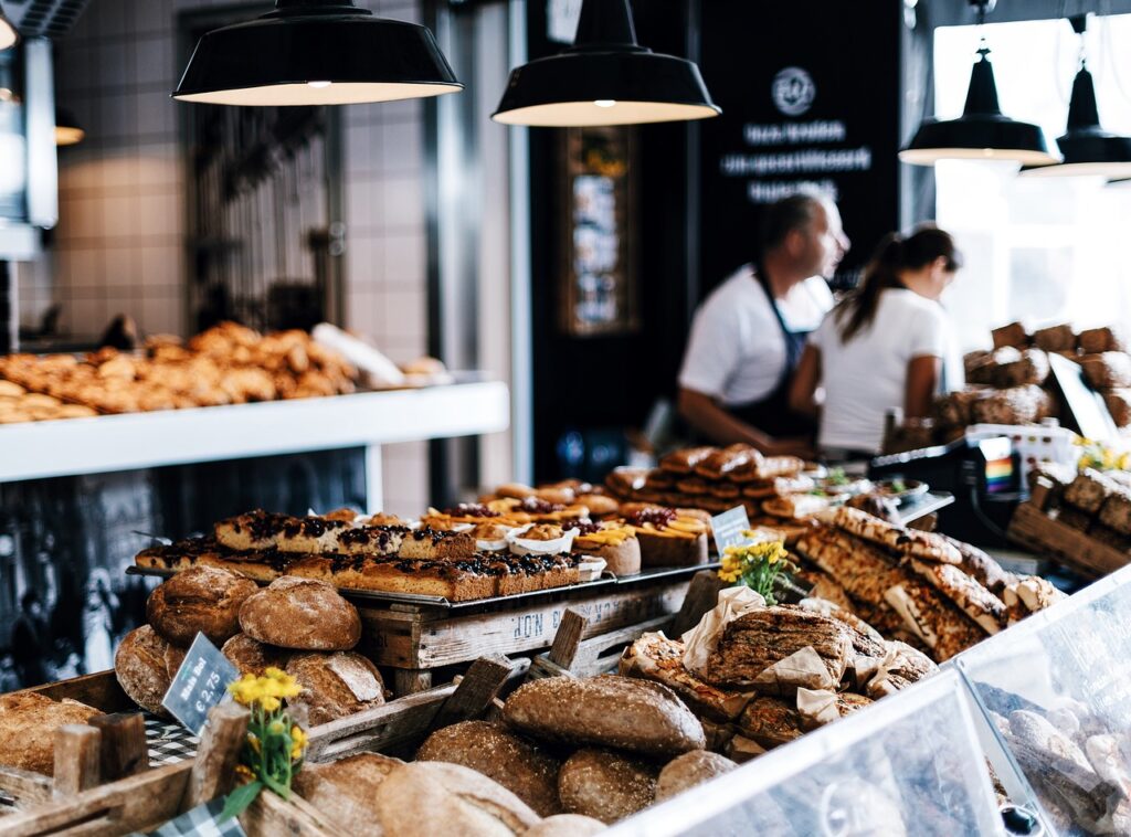 étal d'une boulangerie avec en fond le boulanger et une employée.